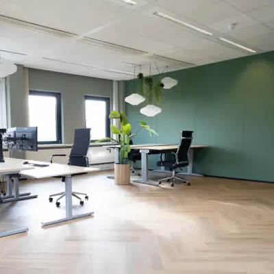 Spacious and modernly furnished office space at Schumanpark 9, Apeldoorn, ideal for rent. Bright area with desks and ergonomic chairs perfect for workstations.