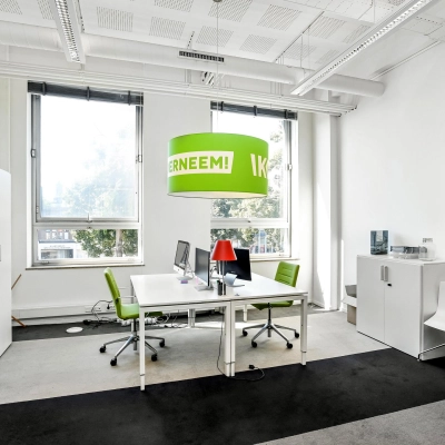 Bright furnished workspace at Jansbuitensingel 7, Arnhem Centrum, ideal for office space rental with modern desks, chairs, and large windows.