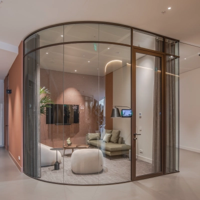 Contemporary furnished office space for rent at Rijksweg-West 2, Arnhem Zuid, featuring a glass-enclosed meeting area with modern seating and plants.