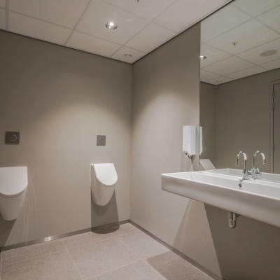 Public restroom with two urinals and a large white sink, ideal for businesses seeking office space rental at Rijksweg-West 2 in Arnhem Zuid.
