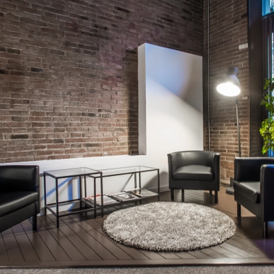 Inviting office space with modern furnishing, including three black chairs and a round rug, located in Barcelona Eixample. Ideal for office space rental with a touch of style.