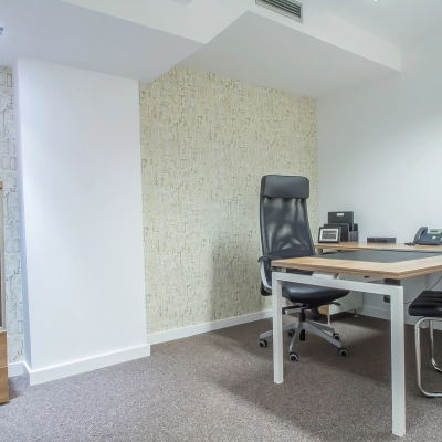 A furnished office space with a desk, chair, lamp, and potted plant at Carrer d'Aribau 161 in Barcelona Eixample, ideal for rent office space needs.
