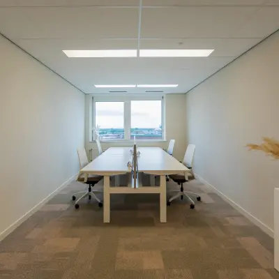 Interior view of a furnished office space rental at Baron van Nagellstraat 136, Barneveld with two desks and chairs, offering a bright and simple working environment.