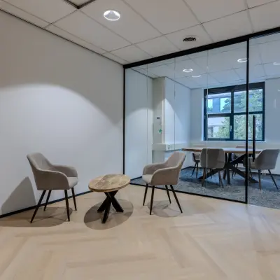 Modern office space to rent at Rijtuigweg 10, Bergen op Zoom, featuring a small seating area with two chairs and a table.
