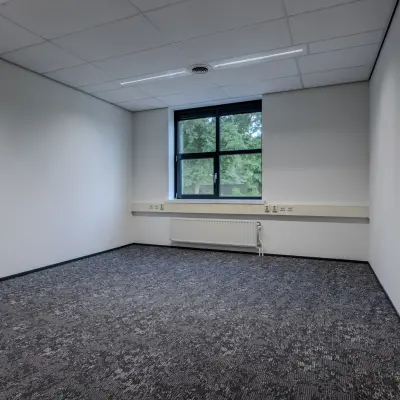 Unfurnished office space with carpet flooring and large window, ideal for rent office space at Rijtuigweg 10, Bergen op Zoom.