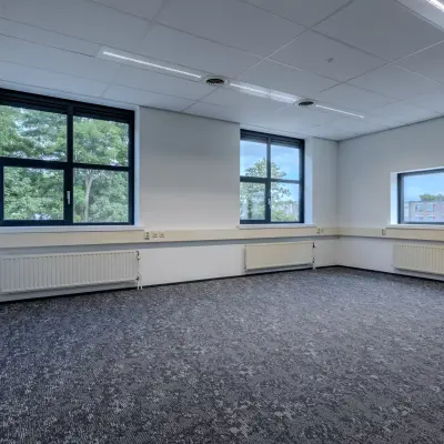 Unfurnished office space with large windows and patterned carpeting at Rijtuigweg 10, Bergen op Zoom, available for rent.