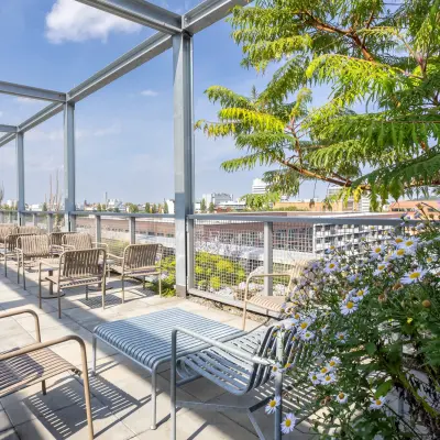 Open terrace space at Heidestraße 34, Berlin Mitte, featuring outdoor seating and greenery, ideal for informal meetings or relaxation. Perfect for those seeking versatile office space rental.
