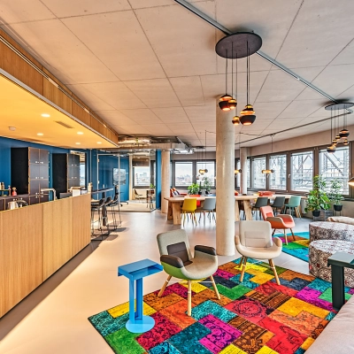 Spacious and colorful office interior on EUREF-Campus 22 in Berlin Schöneberg, featuring vibrant furnishings and ample natural light, ideal for those seeking a dynamic office space rental.