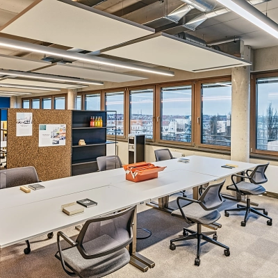 Bright office space at EUREF-Campus 22, Berlin Schöneberg, featuring ample desks and ergonomic chairs, ideal for business activities with a captivating view.