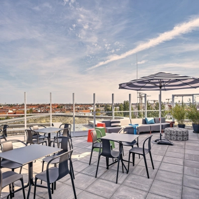 Modern rooftop terrace at EUREF-Campus 22 in Berlin Schöneberg, offering panoramic views and plentiful seating, ideal for informal meetings. An attractive option for office space rental.