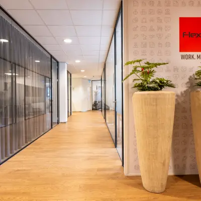 Modern office space in Bodegraven at Marktstraat 1-7 with stylish decor, featuring large planters and glass partitions, available for rent.