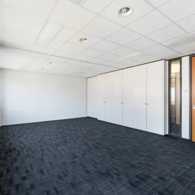 Unfurnished office space at Tolnasingel 1 - 3, Bodegraven, with a carpeted floor, white walls, and large windows. Ideal for office space rental.