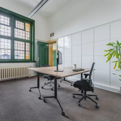 Bright office space at Ceresstraat 13, Breda Centrum-Station, featuring a large window and minimal furnishings, ideal for rent office space seekers.