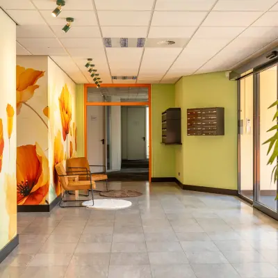 Bright entrance with floral murals at Takkebijster 57A, featuring office space rental opportunities in Breda Oost-Brabantpark.