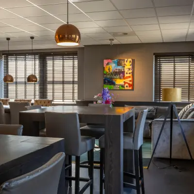Furnished office space rental at Takkebijster 57A, Breda Oost-Brabantpark, featuring modern seating, tables, and decorative lighting.