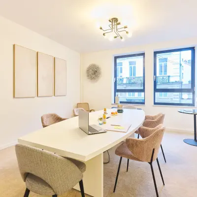 Bright office space at Rue du Congres 37, Brussels Center, showcasing a contemporary meeting area with a long table and modern chairs, available for rent.