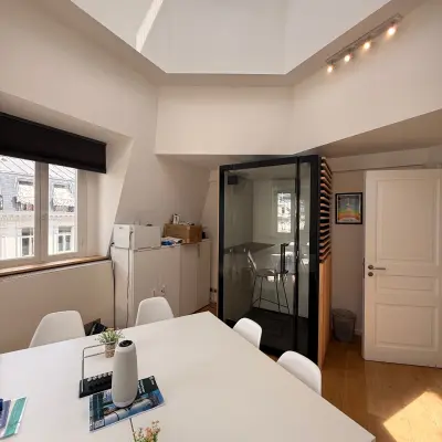 Sunny office to rent at Rue du Congres 37, Brussels Center, featuring a meeting pod and natural light through skylights.