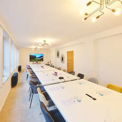 Spacious conference room at Rue du Congres 37, Brussels Center, featuring modern lighting and long tables ideal for office space rental.