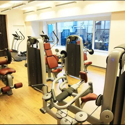 Modern gym facility available for rent office space at Rue Joseph Stevens 7, Brussels Center, equipped with fitness machines and large windows for natural light.