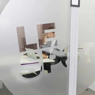 Interior view of an office space rental on Rue Joseph Stevens 7, Brussels Center, featuring a person working at a desk with a laptop.