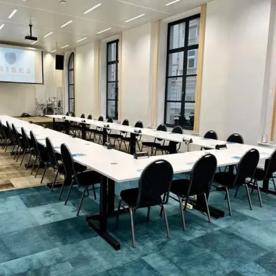 Spacious, well-lit office to rent on Rue des Colonies 56, Brussels European District, featuring a long conference table with multiple chairs.