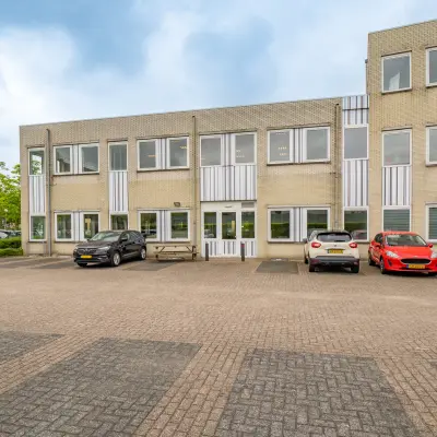Exterior view of office space for rent at Regulierenring 2, Bunnik, showing a two-story building with parking area.