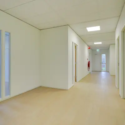 Bright hallway in an office space to rent at Regulierenring 2, Bunnik, with light wood flooring and white walls.