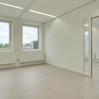 Bright office space with large windows and neutral tones, located at Regulierenring 2, Bunnik. Ideal for office space rental.