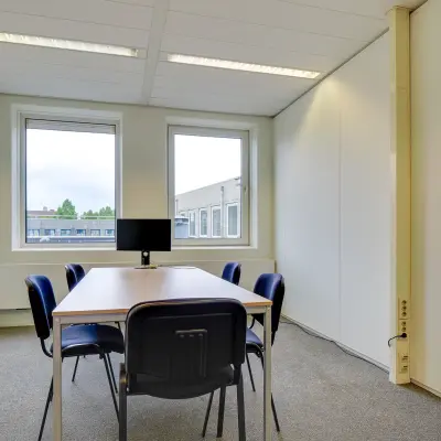 Bright office space at Regulierenring 2, Bunnik, featuring a table with chairs and a monitor in a well-lit environment, ideal for rent office space.