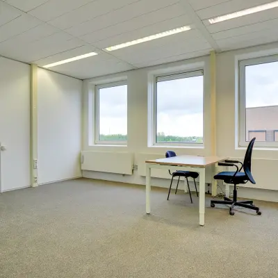 Unfurnished office space for rent at Regulierenring 2, Bunnik, with two windows and a carpeted floor.