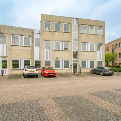 Exterior view of office building at Regulierenring 2, Bunnik, with parked cars and available office space to rent.