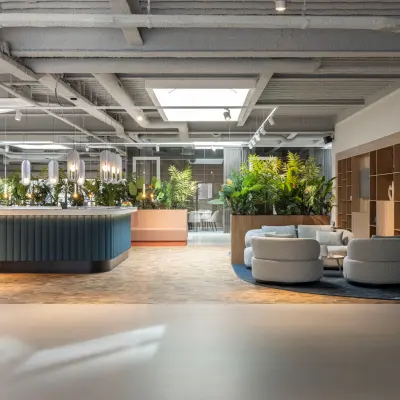Modern office lounge at Essebaan 63, Capelle aan den IJssel, featuring stylish seating areas and lush greenery, ideal for office space rental and informal meetings.