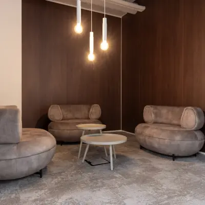 Furnished office lounge area with modern brown sofas and round tables, ideal for office space rental at Essebaan 63, Capelle aan den IJssel.