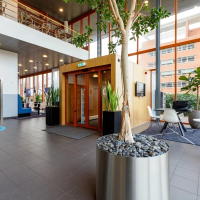Modern office entrance at Fascinatio Boulevard 562, Capelle aan den IJssel, featuring sleek decor with seating area and plants, ideal for office space rental.