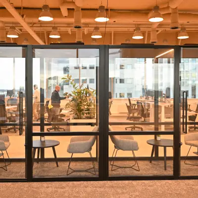Modern office space to rent at Rivium Quadrant 75, Capelle aan den IJssel, featuring glass-enclosed meeting rooms and collaborative workstations.