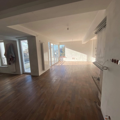 Unfurnished office space featuring wooden floors and large windows offering ample natural light, perfect for office space rental. Located in Cracow Podgorze Duchackie, ideal for those seeking rent office space.