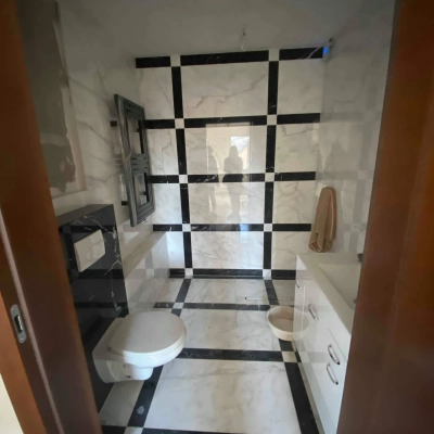 A restroom at Jastrzębia 24, Cracow Podgorze Duchackie, includes modern amenities with a stylish black and white tile design, ideal for an office space rental.