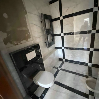 A tiled restroom in an office to rent at Jastrzębia 24, Cracow Podgorze Duchackie. The space features black and white marble tiles, a toilet, and a modern design.