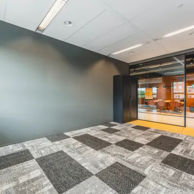 Modern office space to rent at Rijnzathe 12, De Meern, featuring carpeted floors and glass walls separating a visible meeting area.