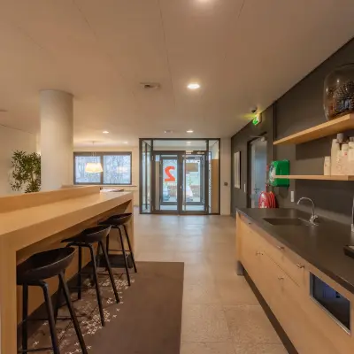Modern interior view of office space for rent at Marshalllaan 2, Delft, featuring a kitchenette with seating area and ample natural light.