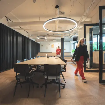 Modern office space at Hambakenwetering 1, Den Bosch, featuring a large table and circular lighting, ideal for office space rental.