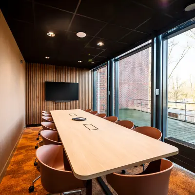 Modern conference room in Hambakenwetering 5, Den Bosch with large windows and a long table, available for office space rental.