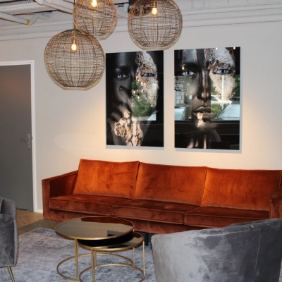 Stylish office space for rent at Keulenstraat 1, Deventer, featuring elegant seating with art-adorned walls and modern lighting.