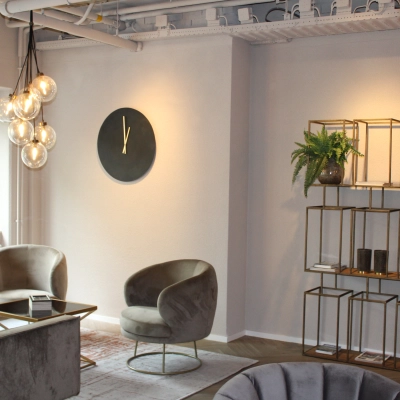 Modern, furnished office lounge at Keulenstraat 1, Deventer, suitable for office space rental with stylish seating and decorative shelving.