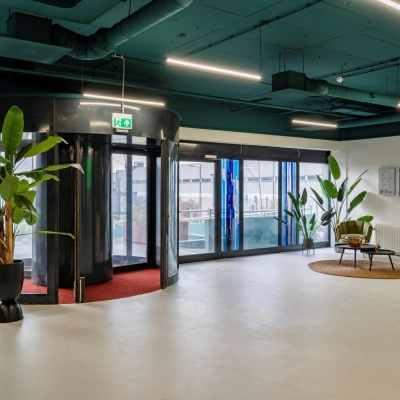 Spacious office entrance at Staverenstraat 15-17, Deventer, featuring modern design with potted plants and natural light. Ideal for those seeking office space rental.