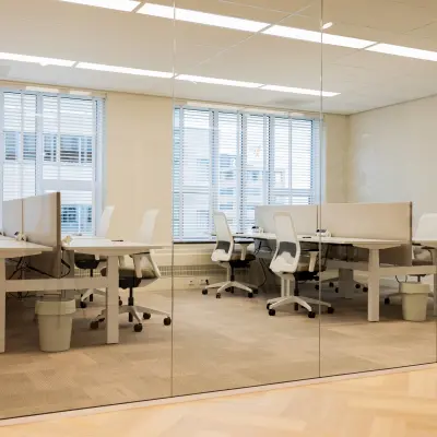 Bright office space available for rent at Diemerhof 42, Diemen, featuring modern workstations and ample natural light through large windows.
