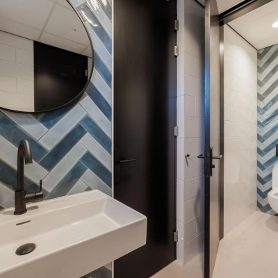 Modern restroom with blue and white tile design at an office space rental, Wisselwerking 40-48, Diemen.