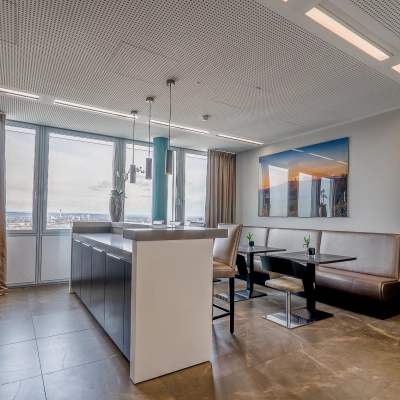 Bright office space to rent at Dreischeibenhaus 1, Düsseldorf Old Town, featuring a cozy seating area with a city view, perfect for office space rental.