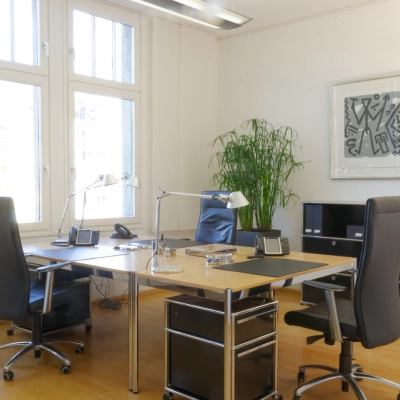 Bright, furnished office space rental at Königsallee 14, Düsseldorf Old Town, featuring two sleek desks, executive chairs, and a large window enhancing natural light.
