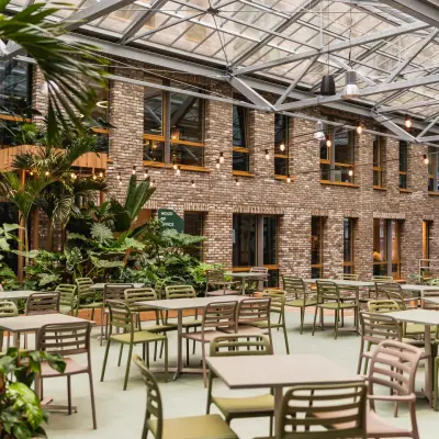 Atrium with abundant seating and greenery at Flight Forum 120-159, ideal for office space rental.